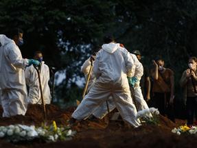 Pessoas enterrando mortos por Covid-19 em cemitério