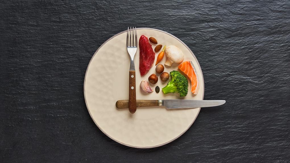 Imagem de legumes e carnes em prato com talheres