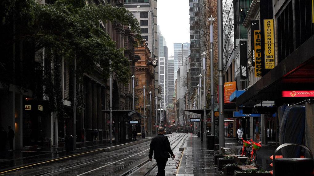 Homem andando em rua vazia na cidade de Sydney, Austrália, durante lockdown