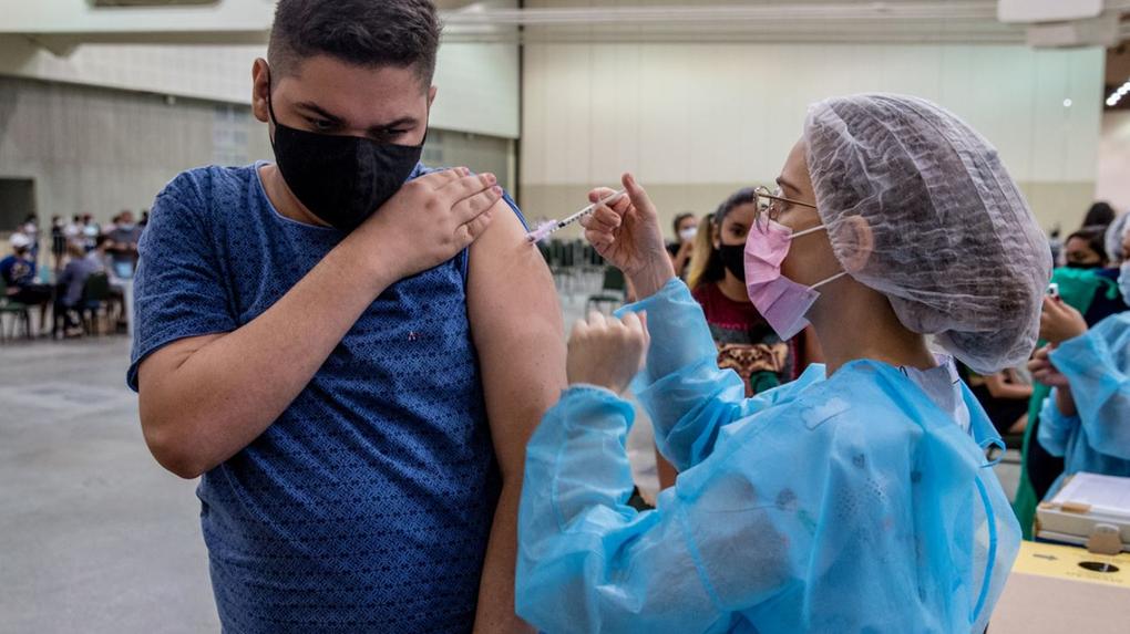 Adolescente sendo vacinado contra Covid-19 por enfermeira no Centro de Eventos