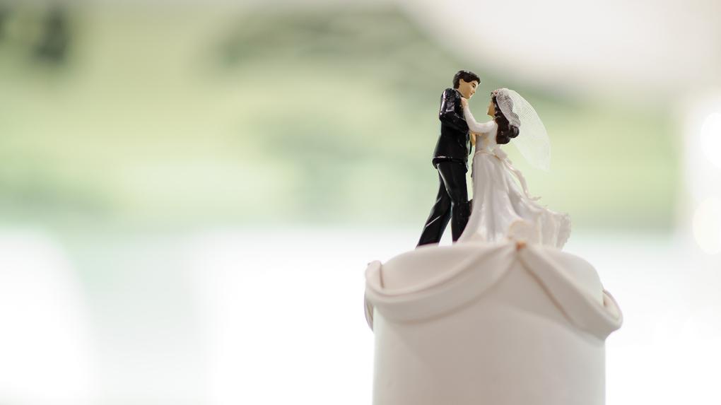 Boneco de noivos em cima de bolo de casamento