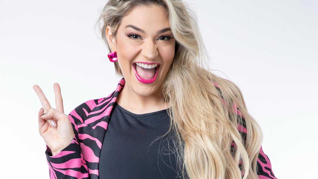 Marília Miranda, participante do 'Big Brother Brasil 23', sorrindo e usando casaco rosa