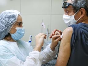 Homem recebe dose de vacina contra a Covid-19