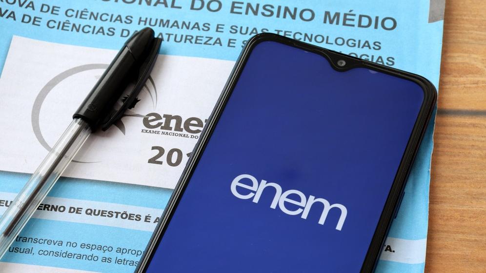 Prova azul do Enem e um celular aberto no aplicativo do exame