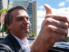 Bolsonaro fazendo joinha com a mão e sorrindo