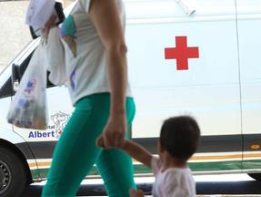 Mãe leva criança passando na frente de ambulância