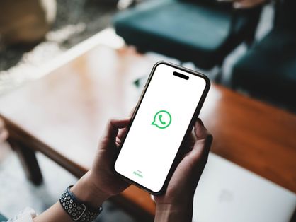 Pessoas segurando celular com aplicativo whatsapp aberto. WhatsApp mudou de cor? Usuários relatam cores branco ou verde no Android e iPhone