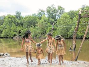 Crianças indígenas em frente a lagoa