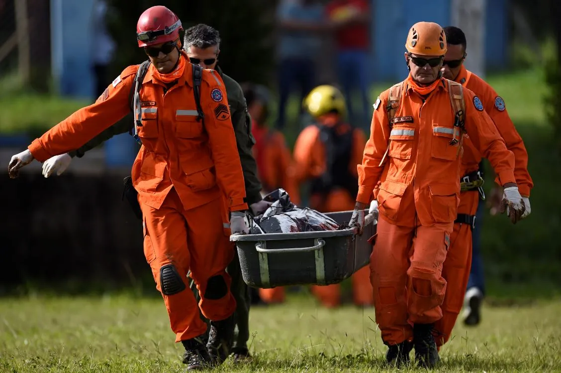 Agentes de resgate levam o corpo de uma das vítimas, recuperado do lamaçal formado no Córrego do Feijão, próximo à Brumadinho. 