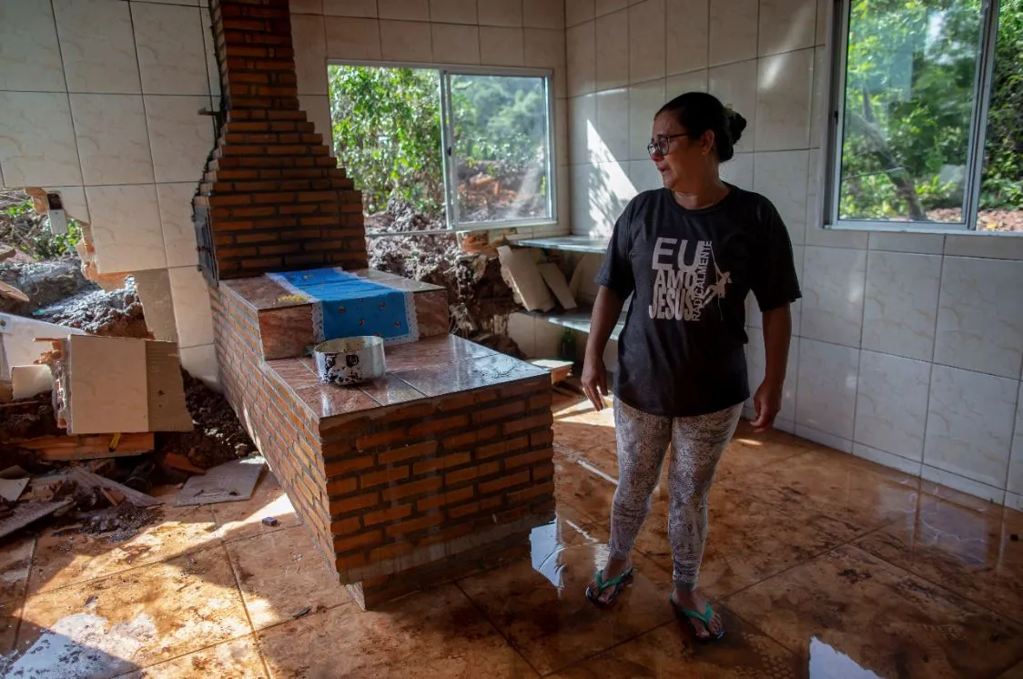 Mulher mostra os destroços da casa onde morava, no Parque da Cachoeira.