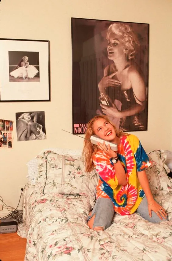 Drew Barrymore com jeans rasgado e camisetão tie-dyie