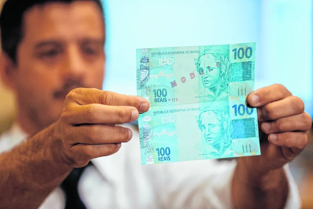 Perito criminal federal realiza comparação entre notas suspeitas e autênticas, para investigação