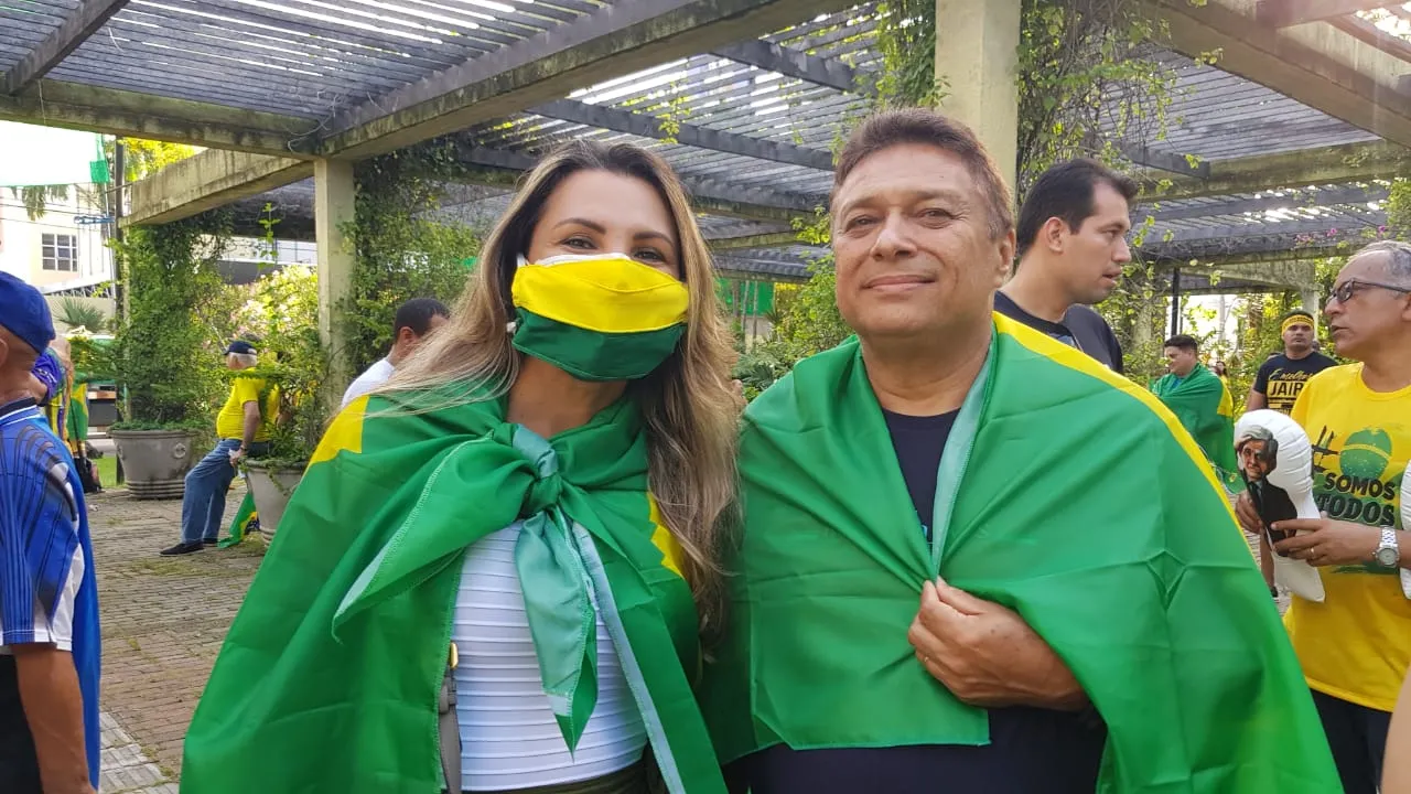 Pessoas com máscaras cirúrgicas pintadas de verde e amarelo durante a manifestação