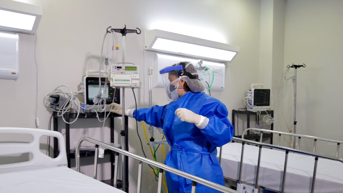 Profissional de saúde prepara leito para receber paciente com Covid-19