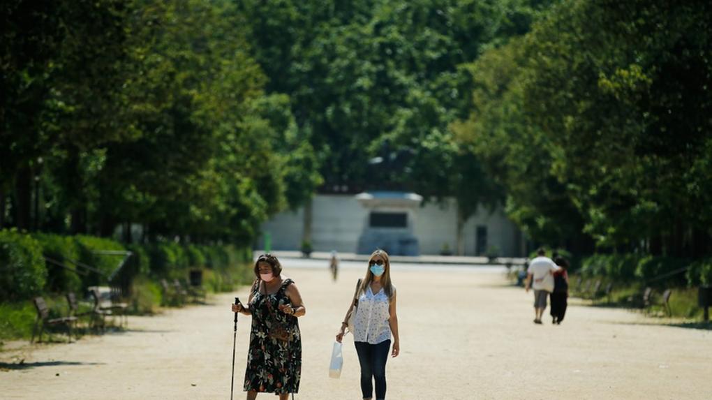 Fotografia de duas mulheres caminhando de máscaras