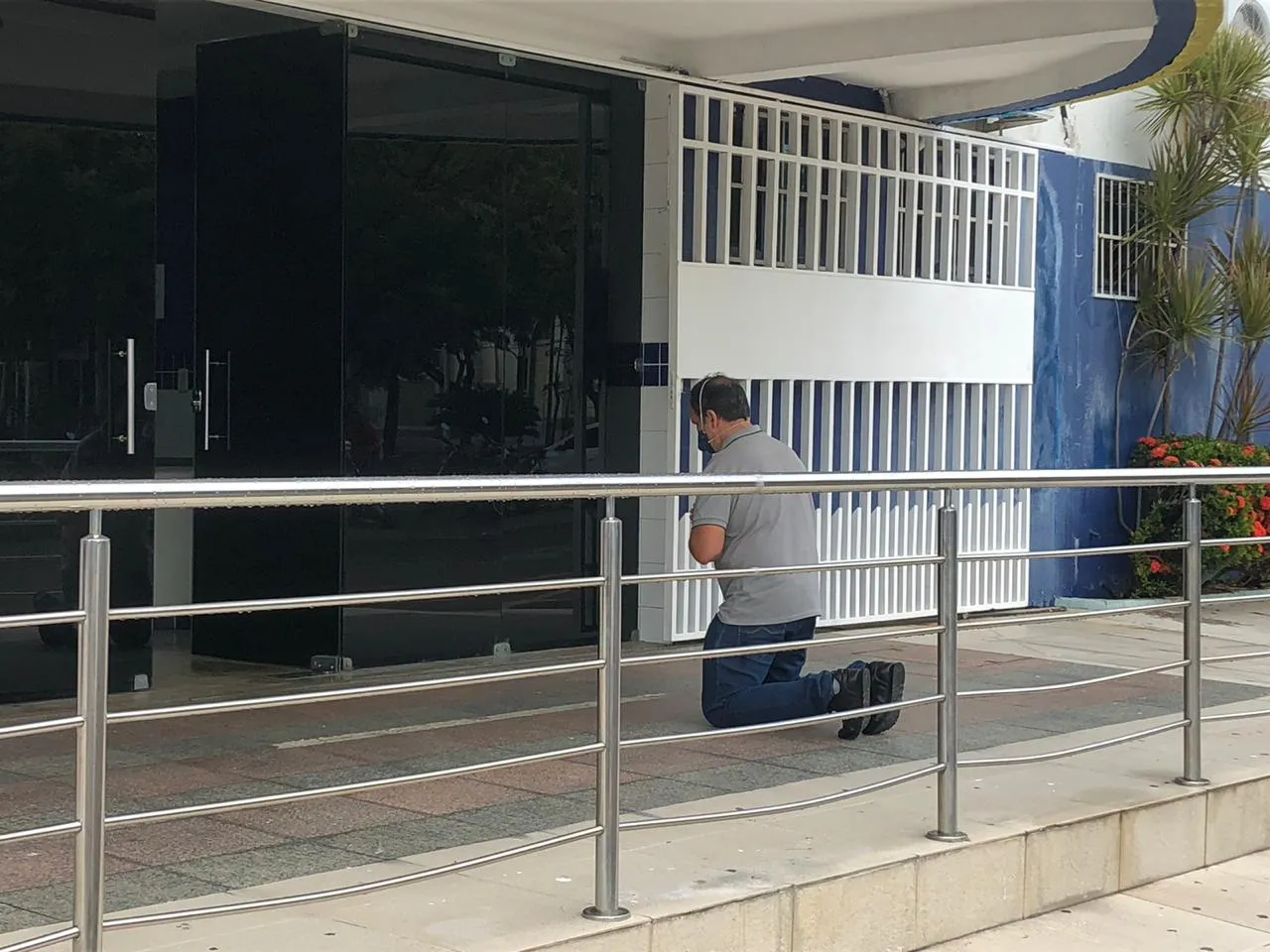 Ao chegar em frente a cada hospital, o ritual se repete: ajoelha-se e reza