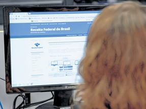 Fotografia de uma mulher acessando o site da Receita Federal
