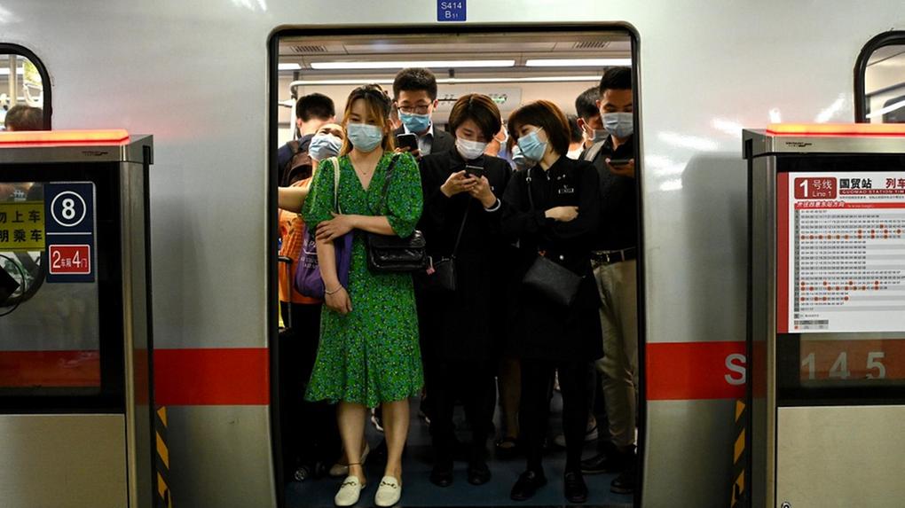 Fotografia de metrô lotado com pessoas de máscara
