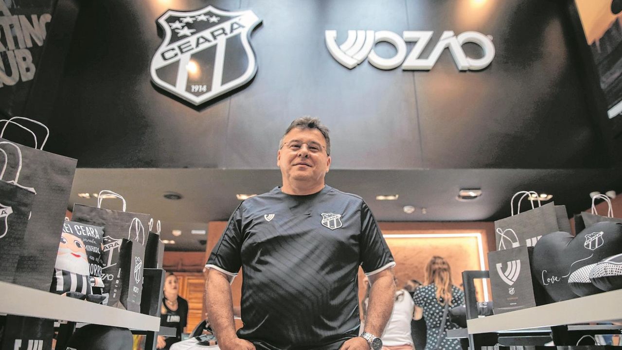Robinson de Castro posicionado na frente de uma loja da marca própria Vozão