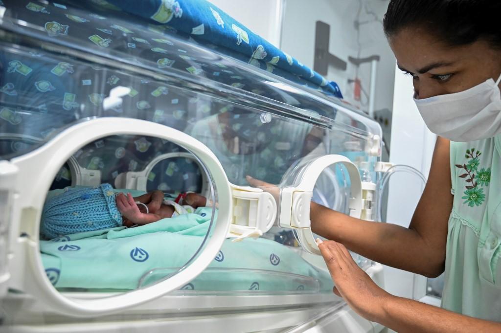 Fotografia da mãe com seu bebê na incubadora