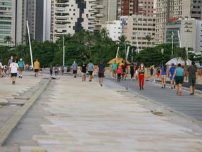 Fotografia mostra pessoas caminhando na Avenida beira-Mar durante pandemia de Covid-19