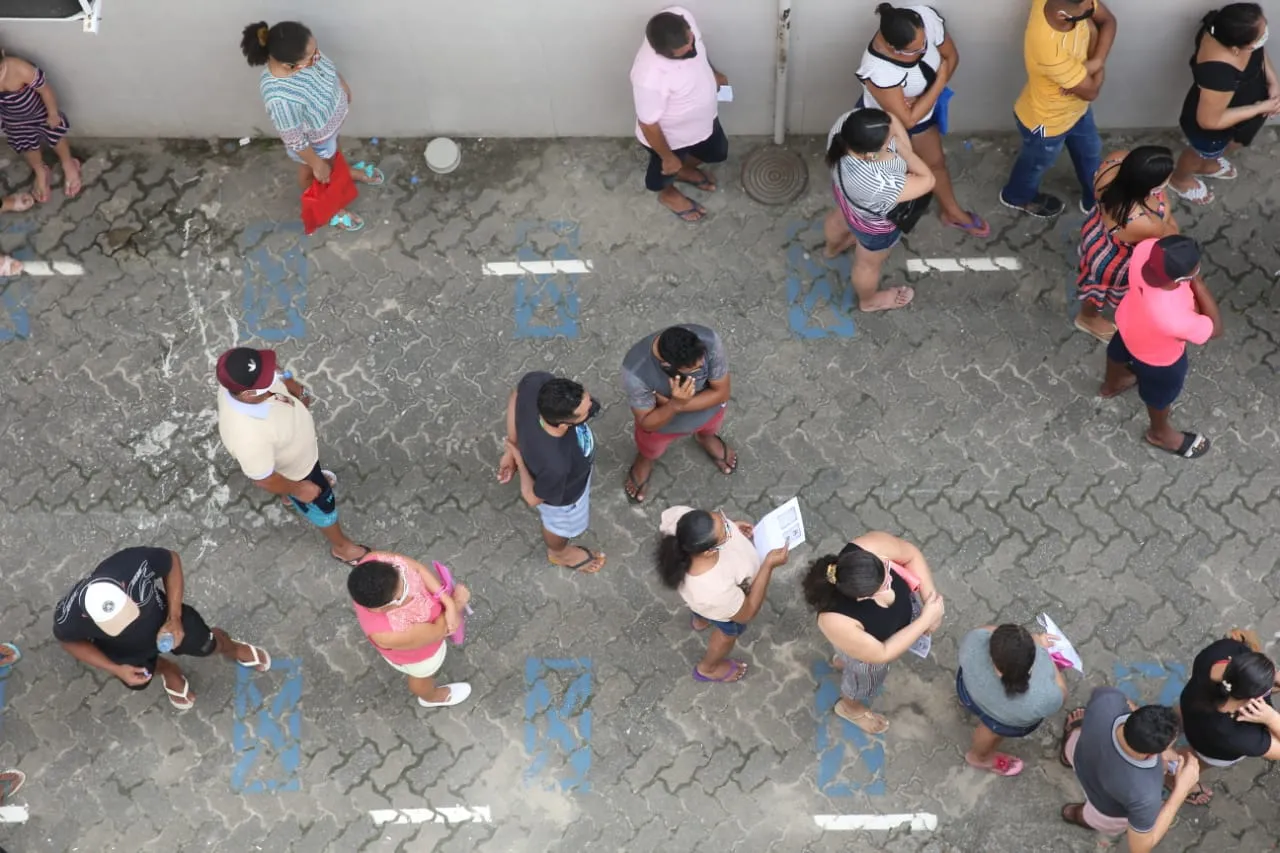 Filas desrespeitam o distanciamento social mínimo ao redor de agência da Caixa em Messejana