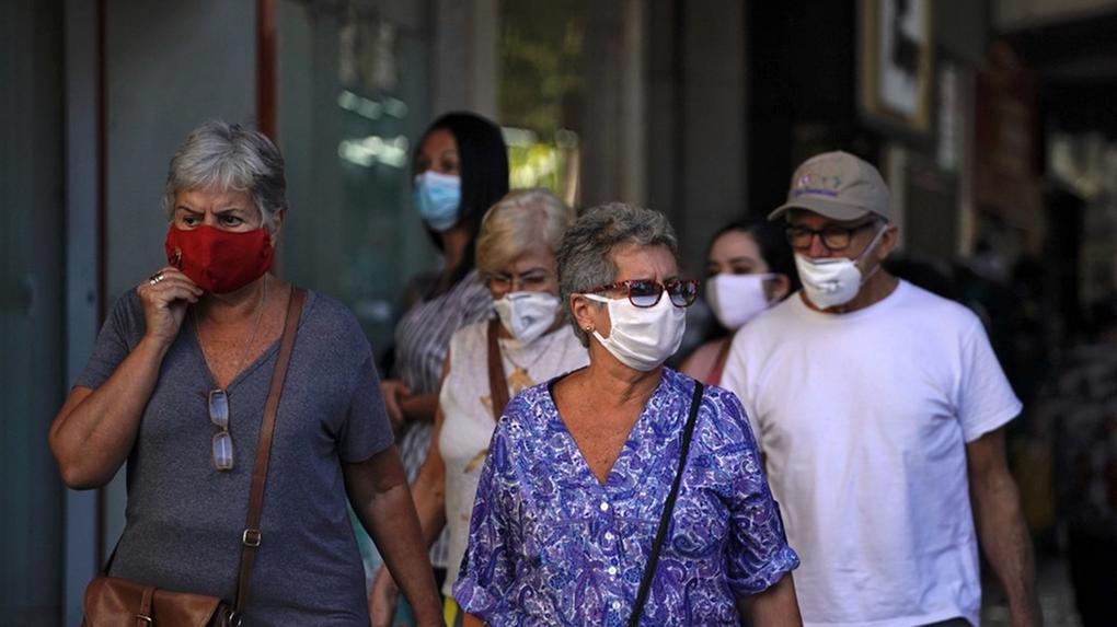 Fotografia de pessoas usando máscaras na rua