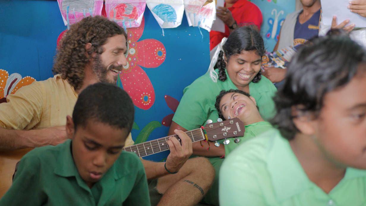 Fotografia do músico com as crianças em Fiji