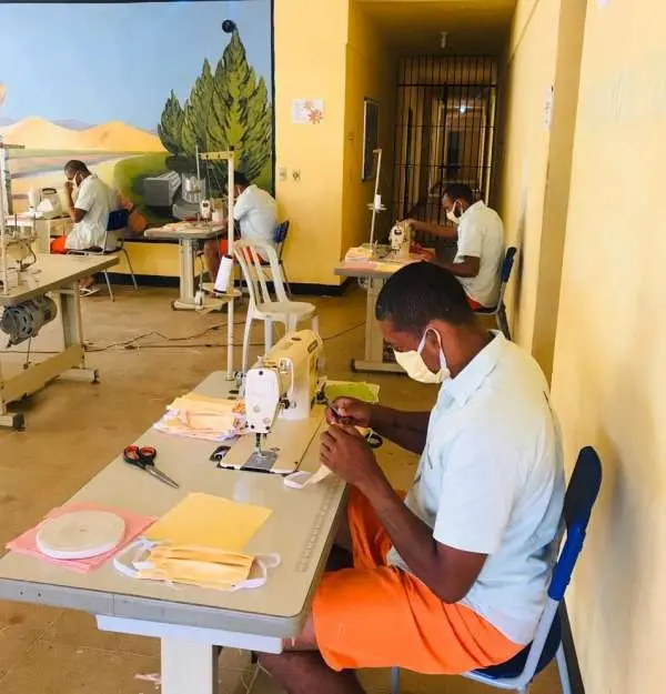 Detentos trabalhando dentro do presídio, mas com máscaras
