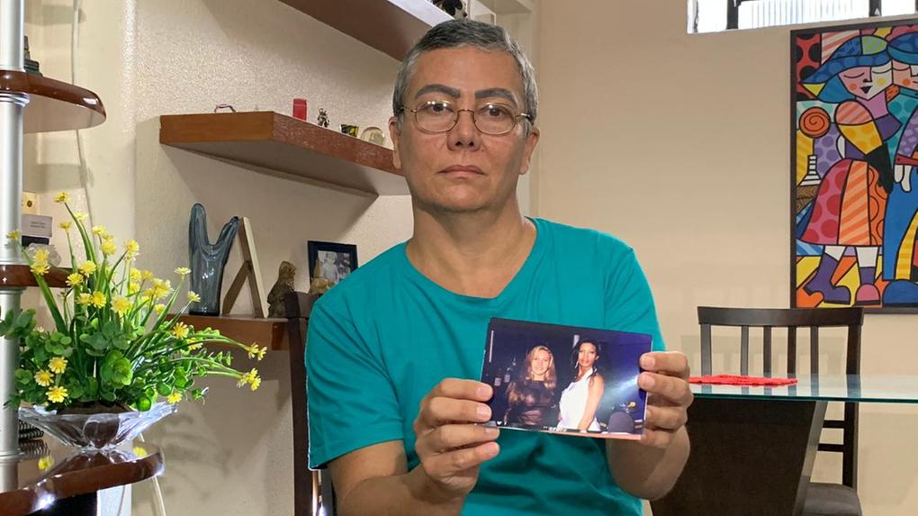 Antônio Teixeira Neto, amigo da vítima, segurando uma foto em que ele aparece, ainda com identidade de travesti, que tinha na época, junto à Manuela