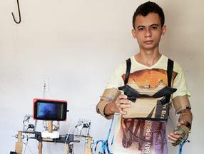 Rapaz veste traje robótico construído com madeira e material reciclável