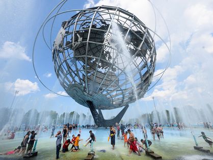 Calor em Nova York, no parque Flushing Meadow Corona Park, no Queens ;AFP People enjoy refreshing water of a fountain in the Unisphere fountain at Flushing Meadow Corona Park in the borough of Queens on July 21, 2019 in New York City. - The US is sweating through a weekend of extremely hot weather, with major cities including New York and Washington bracing for temperatures close to or exceeding 100 degrees Fahrenheit (38 degrees Celsius). (Photo by Johannes EISELE / AFP)