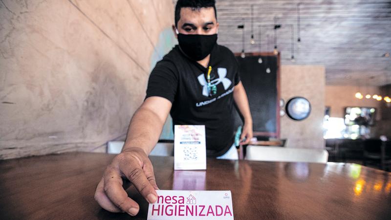 Imagem de um garçom limpando a mesa de um restaurante em Fortaleza