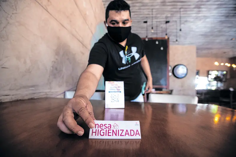 Imagem de um garçom limpando a mesa de um restaurante em Fortaleza