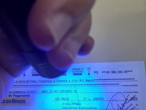 Luz ultravioleta brilha no cheque, o que confirma a falsidade