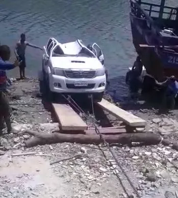 Moradores da região improvisaram uma rampa com madeiras e usaram um trator para retirar caminhonete que caiu em rio no município de Itarema.