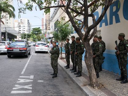 Agentes de tropas federais aglomerados em uma calçada