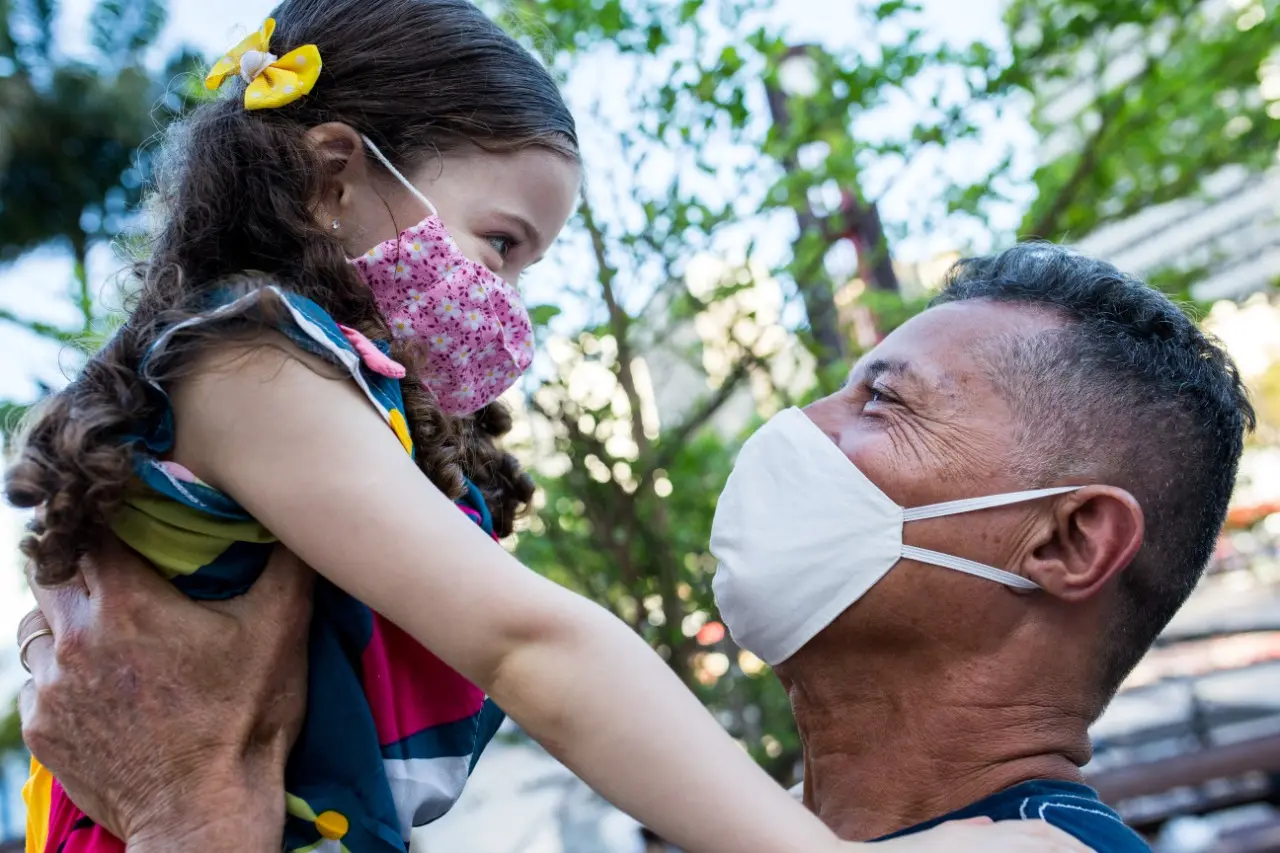 Pedro, de 54 anos, segura a neta Ester, 4 anos