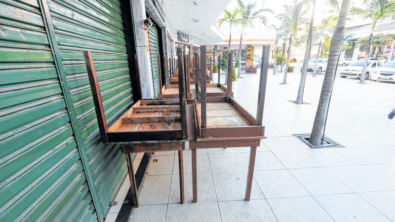 Imagem de um bar fechado com mesas sobrepostas