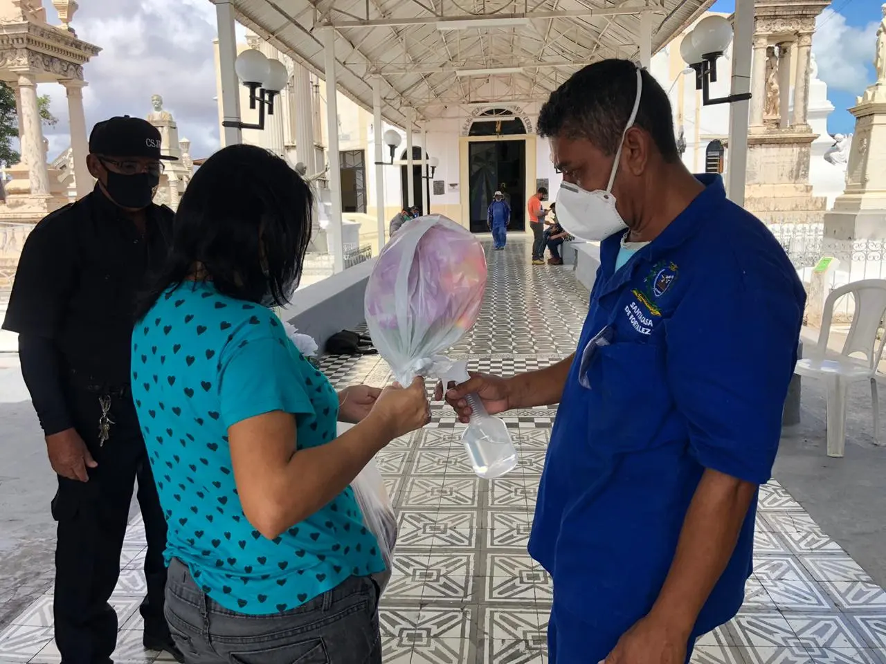 Medição de temperatura e álcool para os visitantes na entrada do cemitério São João Batista, no Centro.