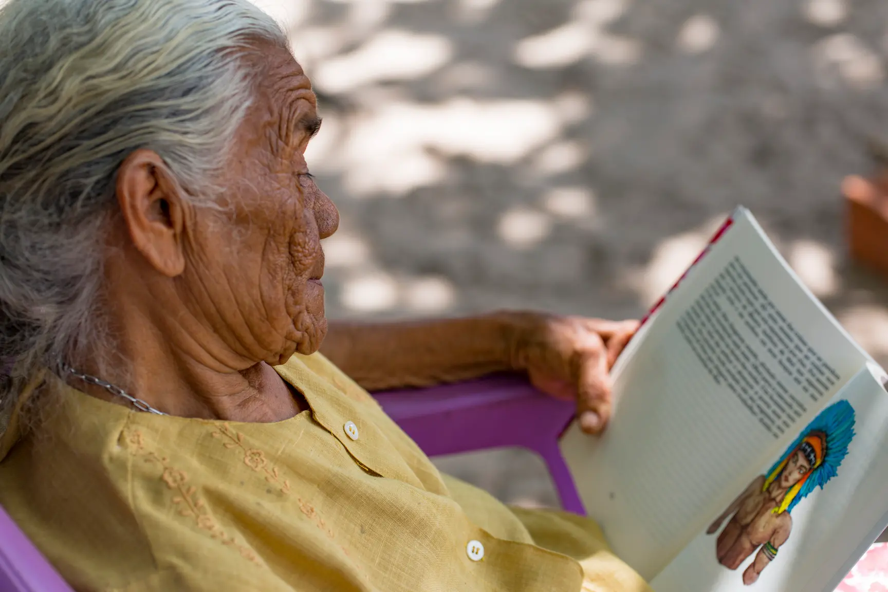 Maria Toinha contempla o livro de sua autoria