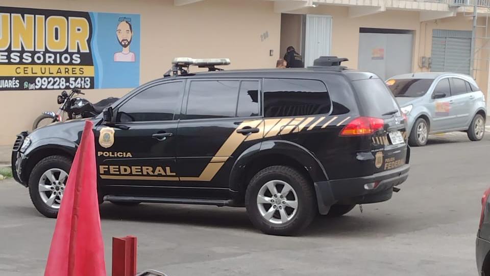 Carro da Polícia Federal estacionado na frente de estabelecimento comercial