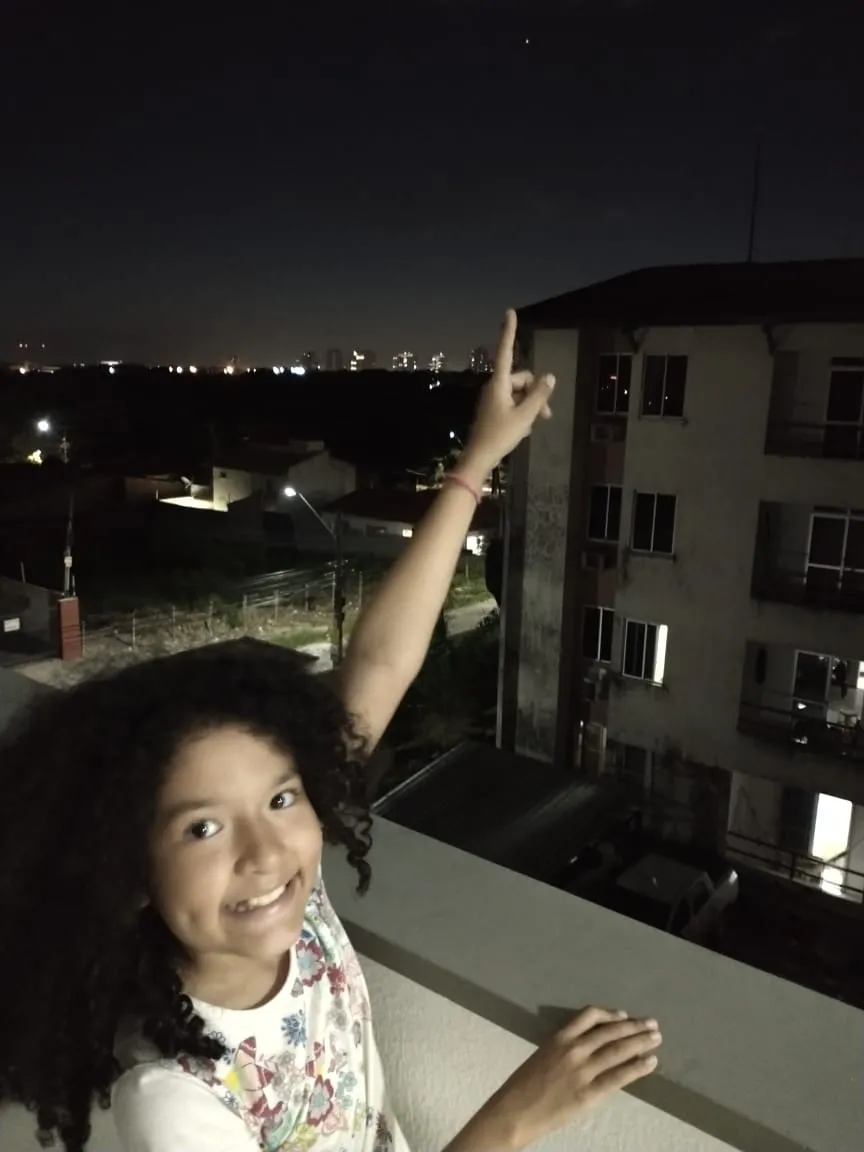 A pequena Janaína acompanha a conjunção entre Júpiter e Saturno no bairro Cambeba, em Fortaleza.