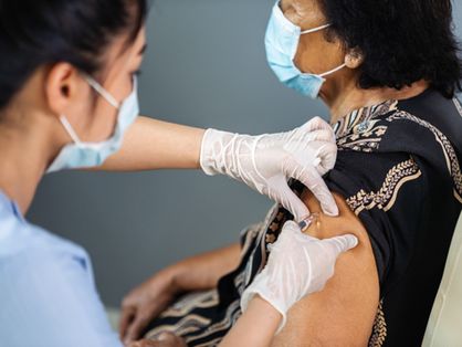 Enfermeira vacinando uma paciente