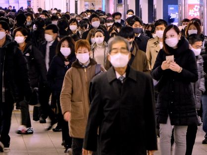 Vários japoneses caminhando mascarados