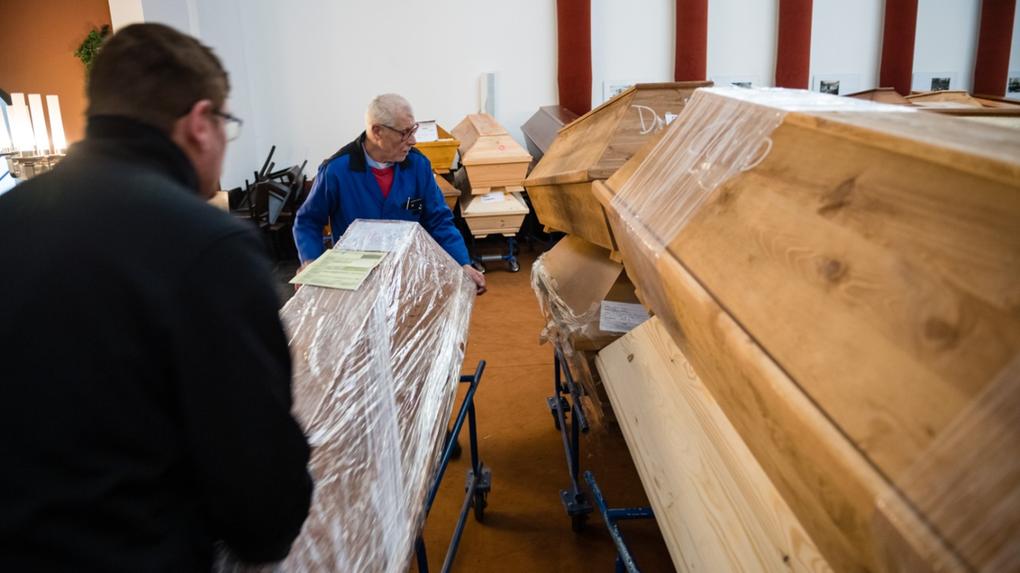 Esta é uma imagem de funcionários deslocando caixões para sala de luto antes da cremação