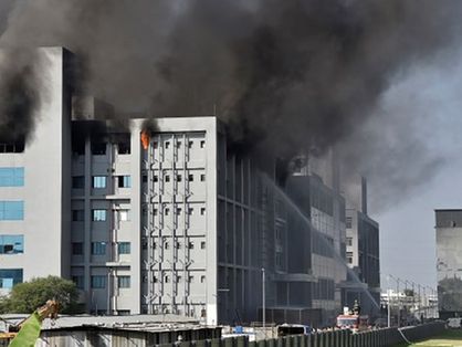 Nesta imagem há o Instituto Indiano de Serum, na Índia, em chamas e bombeiros tentando controlar o incêndio