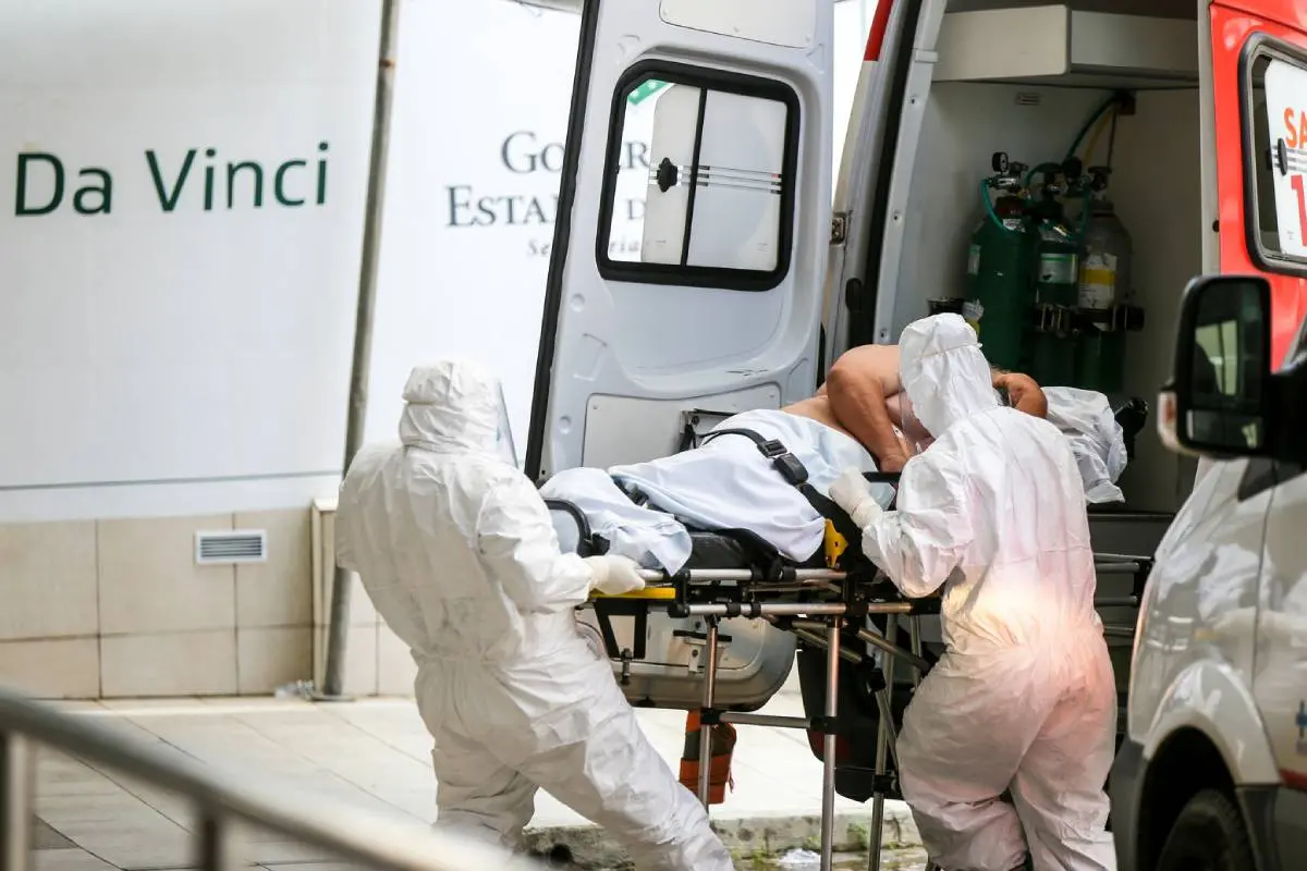 Maqueiros paramentados retiram paciente de ambulância no hospital Leonardo da Vinci em 26/05/2020
