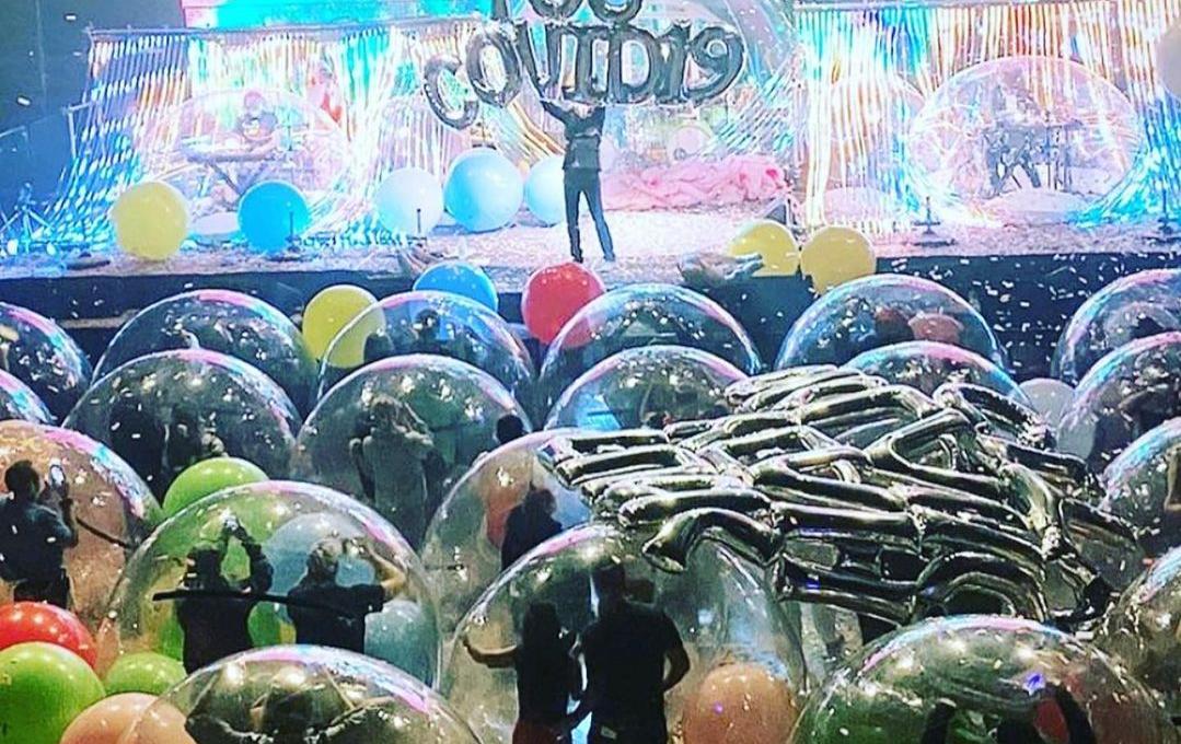 Esta imagem mostra um show da banda Flaming Lips em que o público está em bolhas de plástico transparente gigantes e, no palco, os músicos também estão em bolas infláveis