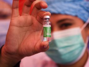 Profissional da saúde segura uma ampola da vacina contra Covid-19 feita pelo laboratório AstraZeneca